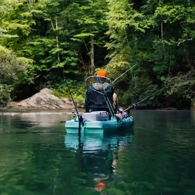 Kayak üzerinde balık avı, sit-on-top kayakta kişi doğal merada av yapıyor.